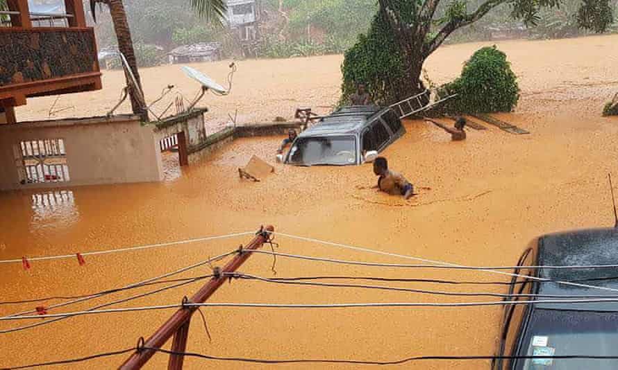 Men up to their shoulders in floodwater in Freetown