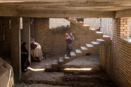 Laalah walks up the stairs with her baby brother, Faakhir, in their home in Balkh province.