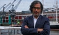 David Olusoga standing with arms crossed next to a city harbour