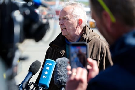 Till Backhaus has microphones pointed at him by reporters