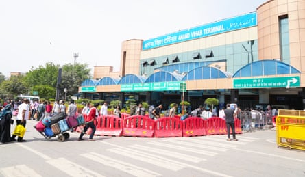 People arrive dragging luggage trolleys at Anand Vihar railway station in Delhi.