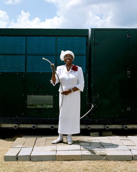 Black woman dressed in white holding a hose