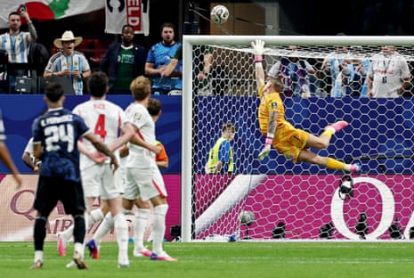England's Jordan Pickford dives as Argentina's Enzo Fernandez shoots narrowly over.