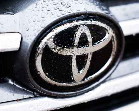 Raindrops are seen on Toyota logo on the front of a silver car