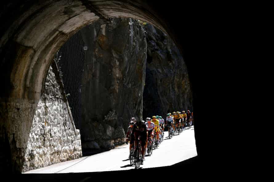 The peloton go through a tunnel as they start the first climb.