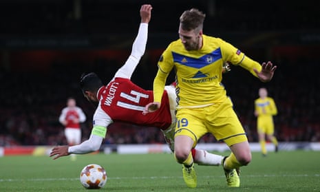 Theo Walcott goes to ground after being barged by Nemanja Milunovic of Bate Borisov and the referee points to the penalty spot.