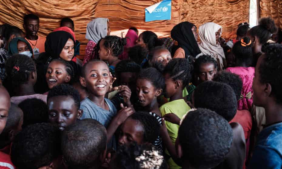 Ethiopian refugee children who fled the Tigray conflict and Sudanese helpers at a space set up by Plan International at the Hamdayet border camp.