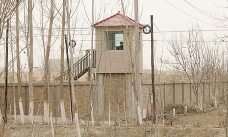 Security guard watches from a tower around a detention facility in northwestern China's Xinjiang Uyghur autonomous region.
