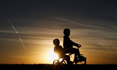 children ride a tricycle in silhouette