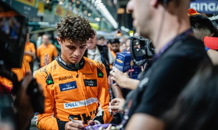 Lando Norris signs an autograph