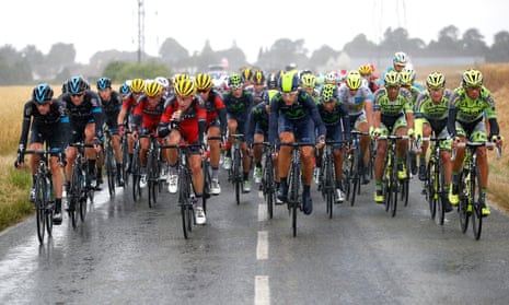 Riders from Team Sky, BMC Racing Team, Movistar Team and Tinkhoff-Saxo work at the front of the peloton in the wet.