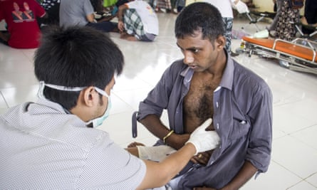 A migrant is given medical treatment at a temporary camp in Kuala Cangkoi village, North Aceh, Indonesia