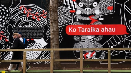 People walk past Māori language signs in Wellington, New Zealand.
