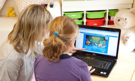 Girl being helped to use a computer