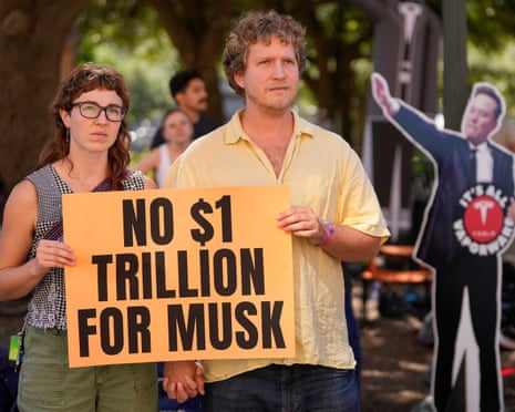 Protesters hold up a placard saying 'No $1 trillion for Musk'