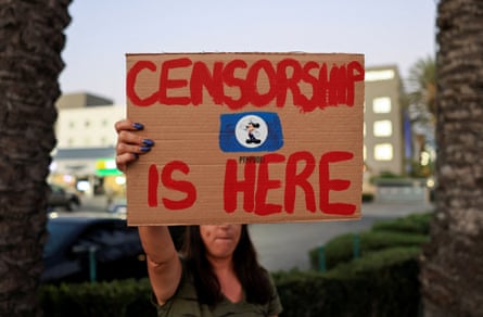 A woman holds a sign during a protest outside Disneyland in California on 19 September, after Jimmy Kimmel’s late-night talk show was suspended for remarks he made about Charlie Kirk’s killing.