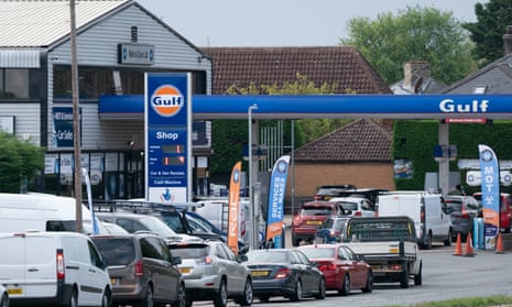 People queue for fuel at a petrol station in Barton, Cambridgeshire.