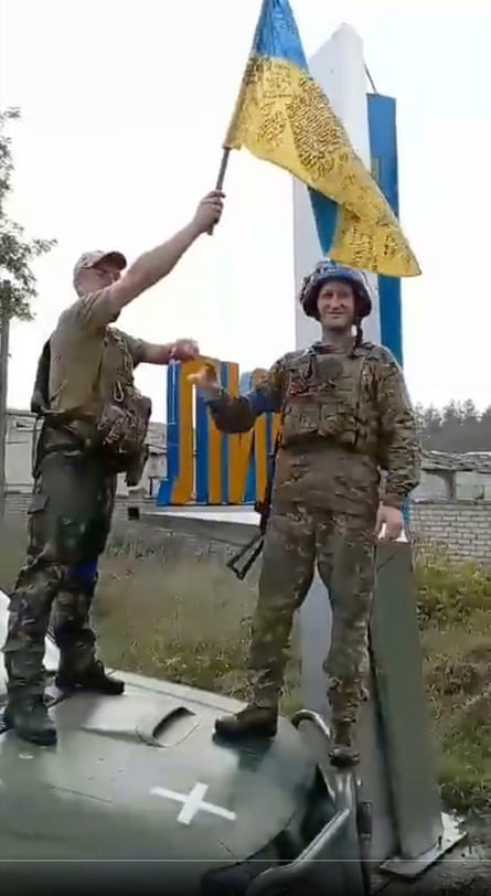 Ukrainian troops raise a national flag in Lyman.