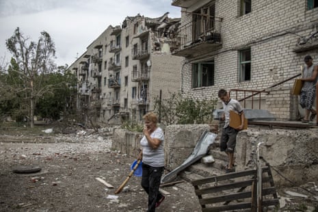 Local residents collect their belongings from their homes damaged by shelling on a residential building in Ukraine’s Donetsk region.