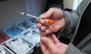 A nurse holds a syringe provided to intravenous drug users taking part in a needle exchange programme