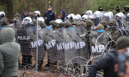Poland’s law enforcement officers watching migrants at the Belarusian-Polish border on 8 November.