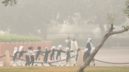 A line of schoolchildren wear face masks as Delhi is engulfed in heavy smog