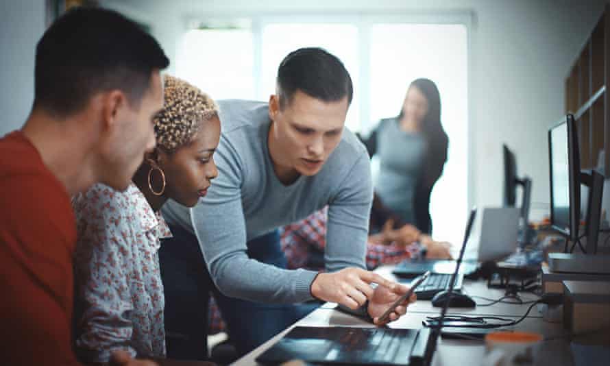 Closeup side view of group of mid 20’s mobile application developers testing the code and fixing the issues.