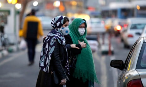 Women wearing face masks walk on a street of Tehran, Iran