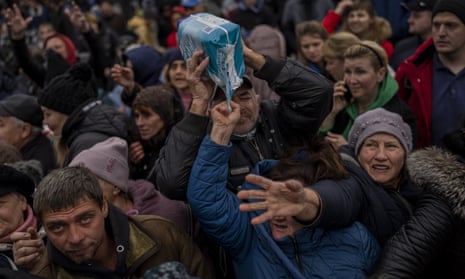 Residents gathering at an aid distribution point receive supplies in downtown Kherson.