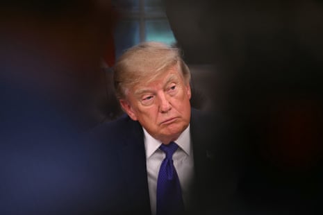 President Trump sits with a serious, contemplative expression in the Oval Office