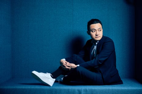 a man in a suit and sneakers posing while seated