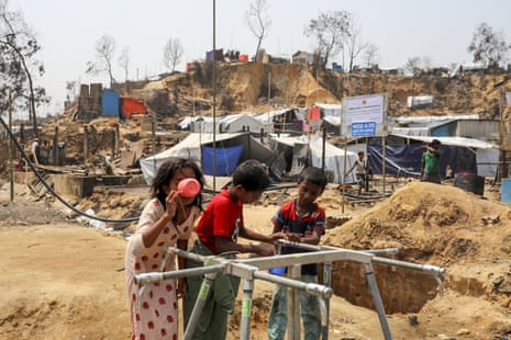 Three children drink safe drinking water provided by an NGO after a massive fire broke at Cox’s Bazar, Bangladesh, 26 March 2021. 