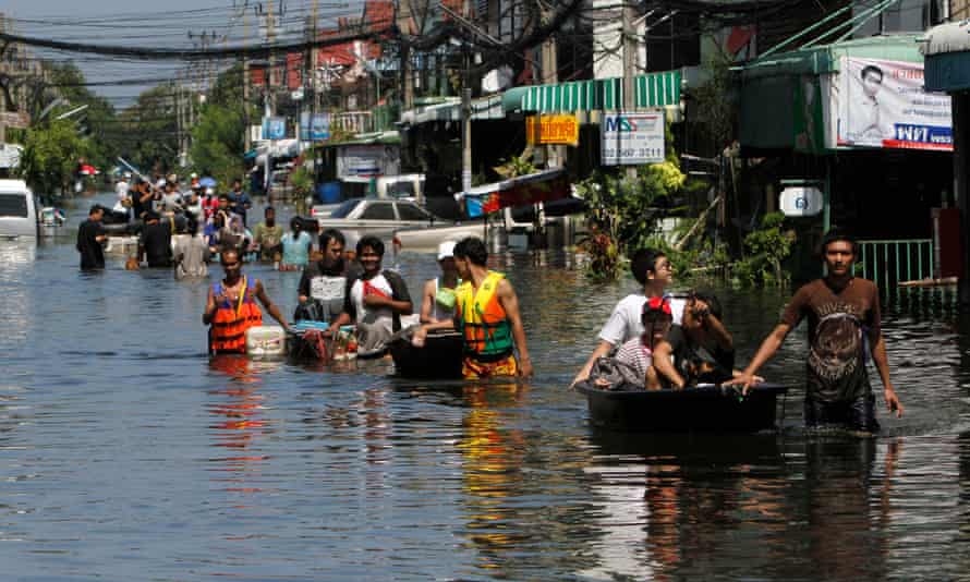 People push their belongings through the water during an evacuation from a flooded area in Bangkok in 2011.