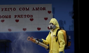 A government employee disinfects a public school in the Taguatinga neighborhood of Brasilia, Brazil, Tuesday, 28 July 2020.