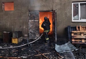 a firefighter in the door of a burning building
