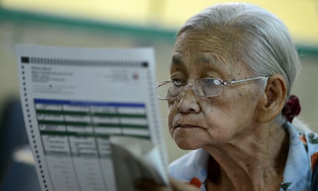 A woman looks at a ballot paper during mid-term elections in Manila on May 13, 2013.