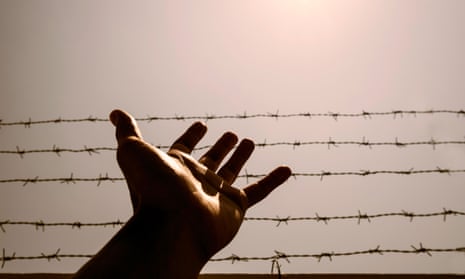 A hand and barbed wire