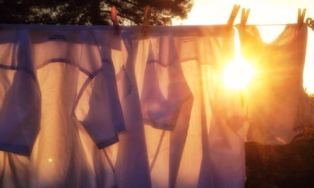 Evening sun shines between two shirts hanging on a washing line in a back garden