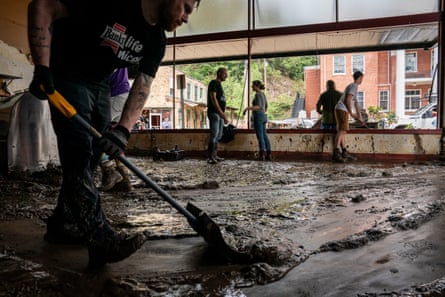 People clean mud from an empty business.