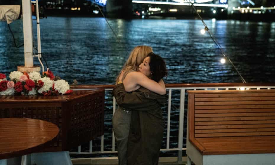 Jodie Comer and Sandra Oh hugging by the Thames in Killing Eve.