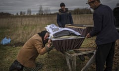 A woman cries over the coffin of her son.