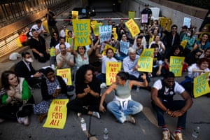people sit on the ground and hold signs that read ‘ice out of NY’