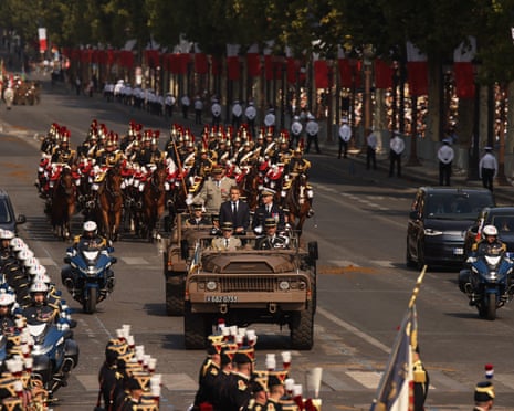 French president Emmanuel Macron and General Chief of Staff of the French armed Forces Fabien Mandon stand in the command car as they review troops during the Bastille Day military parade.