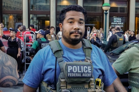 A man in a police vest on a busy city street.