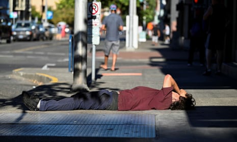 A man covers his face during a heatwave in Portland, Oregon. Temperatures in Portland reached 103F (39C) by late afternoon on Thursday – 20 degrees above average. 