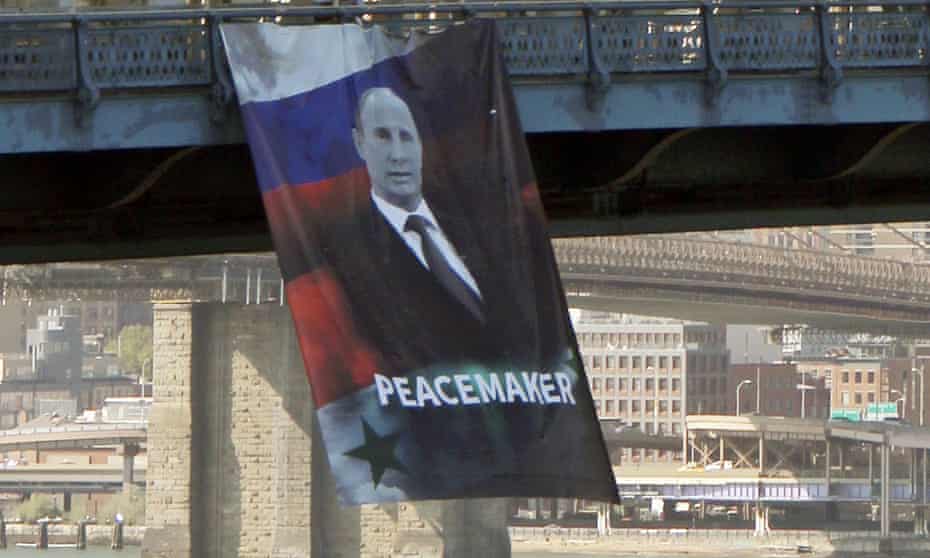 In this photo provided by Gothamist.com, a banner depicting the Russian president, Vladimir Putin, and labelling him a ‘peacemaker’ hangs from the Manhattan Bridge in New York on Thursday.