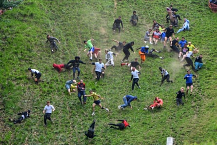 Men fall and tumble down the steep Cooper's Hill in Brockworth during the race