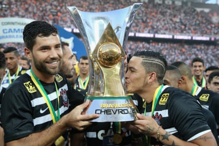 Felipe holds the Brasileirao trophy while his Corinthians teammate Luciano gives it a kiss.