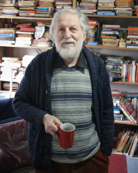 Hornick holds a cup of tea with bookshelves in the background