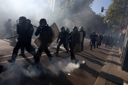 French gendarmes and riot police charge amid teargas during clashes with protesters at a demonstration in Paris
